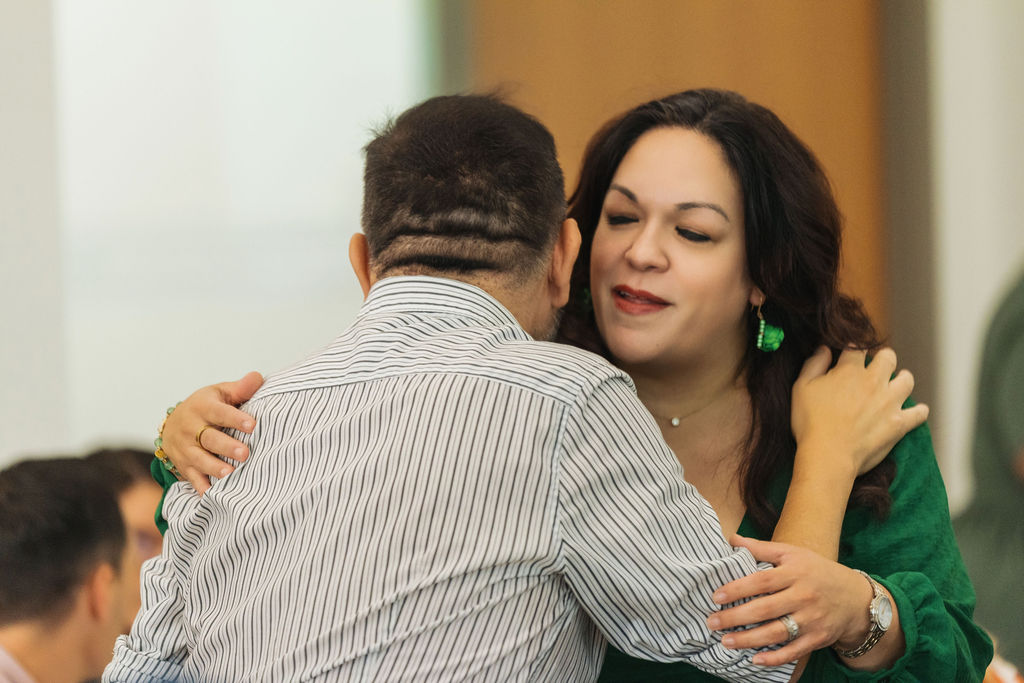 Warm embrace between guests at WE RISE 2025