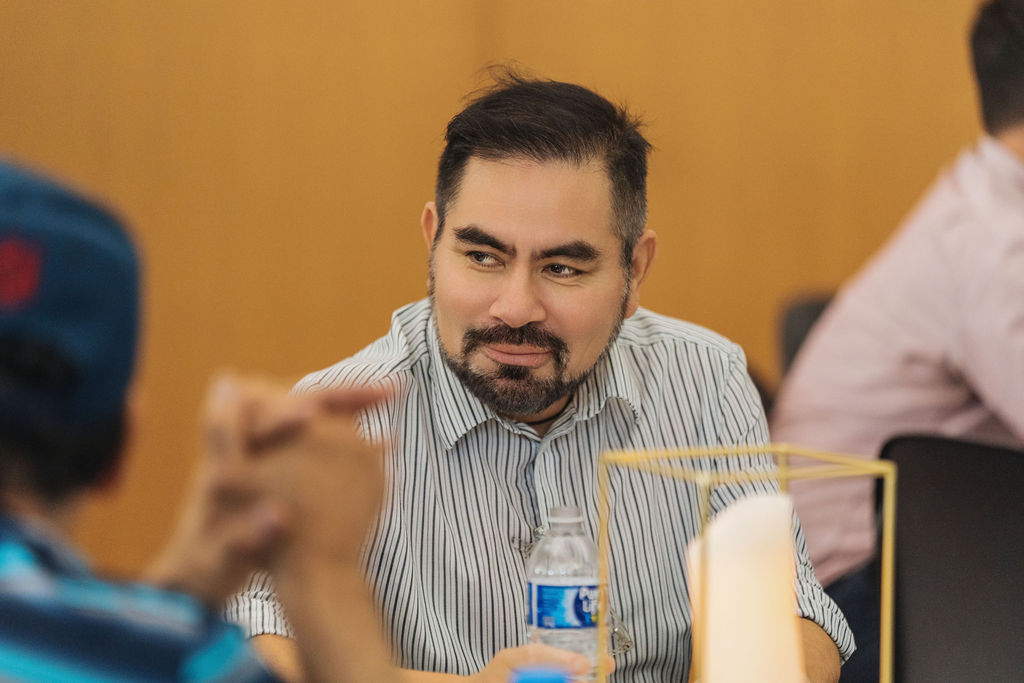 Guest in conversation at his table during WE RISE 2025